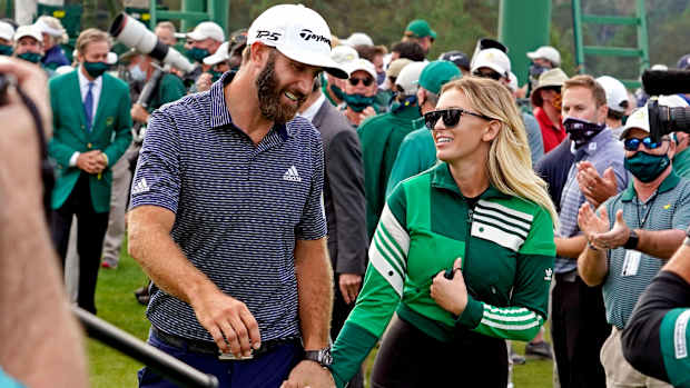 Dustin Johnson and Paulina Gretzky walk off the 18th green at Augusta National while holding hands.